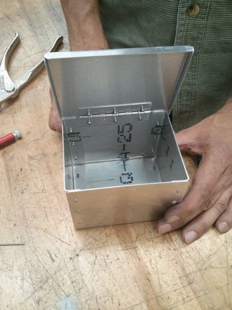 a metal worker is making a box|welding sheet metal boxes.